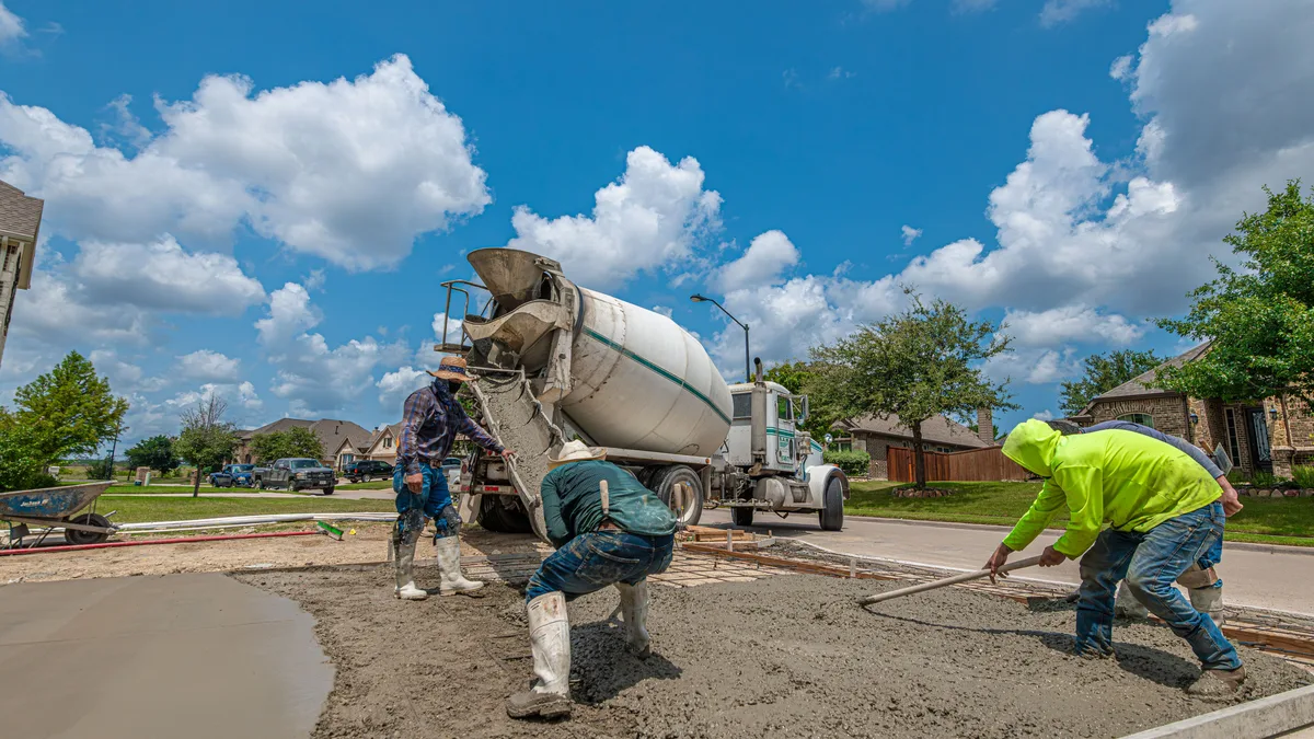 Newly poured concrete residential driveway with a broom finish, curing between forms